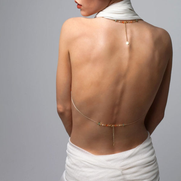 Photo d'une Femme de Dos portant un Bijou de Buste Doré avec Bijoux Swarovski et Jades avec une Tenue couleur Blanc