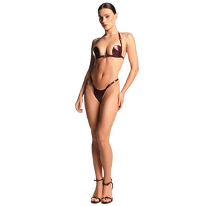 Ensemble deux pièces en cuir bordeaux ANOESES avec soutien-gorge à découpes et string assorti, porté par un mannequin sur fond blanc, vue en pied.