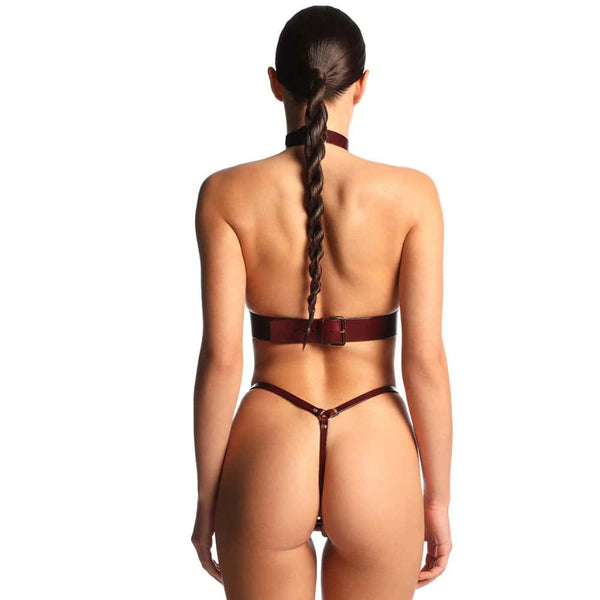 Harnais en cuir bordeaux ANOESES avec sangles réglables et anneaux métalliques, porté par un mannequin sur fond blanc, vue en pied.