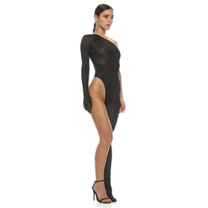 Vue artistique en noir et blanc d’une robe noire asymétrique ANOESES, coupe près du corps avec fente haute et manche unique, portée par un modèle féminin, esthétique minimaliste et fétiche haut de gamme Brigade Mondaine Paris.