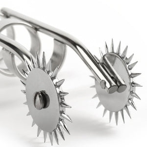 Roulette de Wartenberg à doigts en acier poli avec deux roues crantées et anneaux de maintien, présentée sur fond blanc dans une esthétique minimaliste et professionnelle.