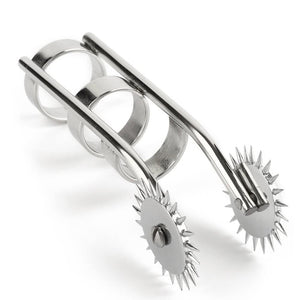 Roulette de Wartenberg à doigts en acier poli avec deux roues crantées et anneaux de maintien, présentée sur fond blanc dans une esthétique minimaliste et professionnelle.