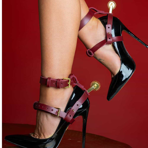 Zoom sur les pieds d'une femme portant des stilettos et le harnais éperons Brigade Mondaine.