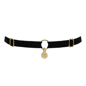 Ici vous pouvez voir le BRIGADE MONDAINE GIFT WRAP BLACK. Ce collier est fait d’une bande noire. 2 détails pour régler les bandes se trouvent à droite et à gauche. Au milieu, la bande est séparée par un anneau plaqué or avec un pendentif ou il est inscrit « BM ».