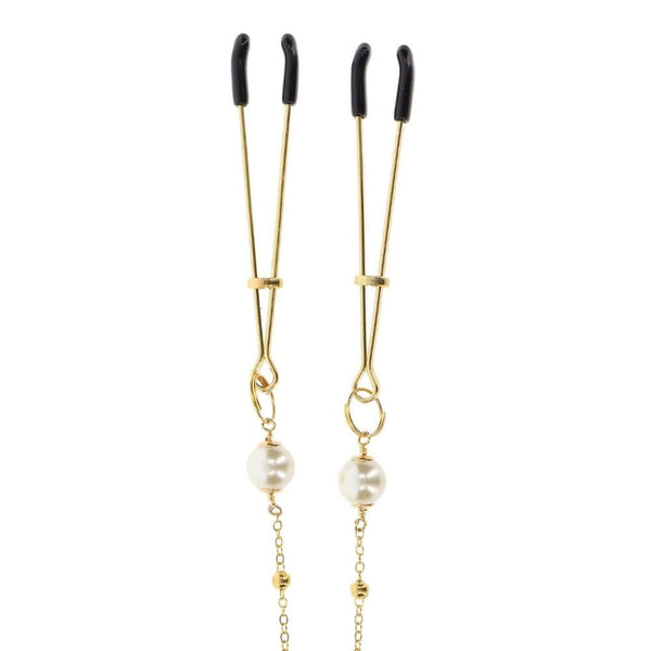 Pinces à tétons dorées avec chaîne fine et perles, portées sur le buste, accessoire sensuel proposé par Brigade Mondaine Paris.