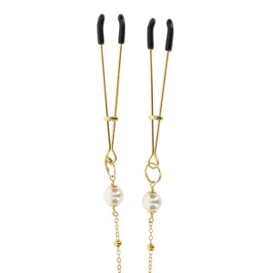 Pinces à tétons dorées avec chaîne fine et perles, portées sur le buste, accessoire sensuel proposé par Brigade Mondaine Paris.