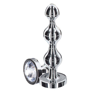 Plug anal en métal poli avec cristal facetté transparent, base évasée et finition brillante, présenté par Brigade Mondaine Paris.