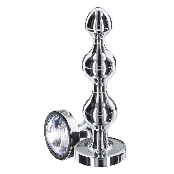 Plug anal en métal poli avec cristal facetté transparent, base évasée et finition brillante, présenté par Brigade Mondaine Paris.