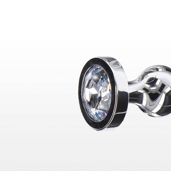 Plug anal en métal poli avec cristal facetté transparent, base évasée et finition brillante, présenté par Brigade Mondaine Paris.