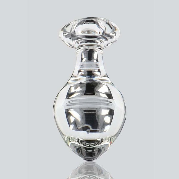 Plug anal en verre transparent poli à finition brillante, forme sphérique avec base évasée, présenté sur fond blanc, sélection Brigade Mondaine Paris.
