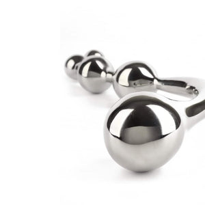 Wand Multi-Stim en acier inoxydable poli, forme incurvée avec extrémités sphériques, présenté sur fond blanc, sélection Brigade Mondaine Paris.