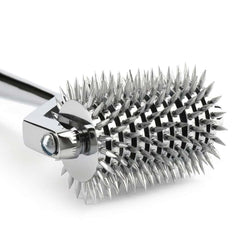 Roulette de Wartenberg en acier inoxydable brillant avec roulettes dentelées, design médical revisité, présentée par Brigade Mondaine Paris sur fond clair.