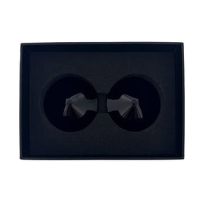 Modèle portant des cache-tétons noirs Seduction à surface lisse avec pointe conique centrale, photographiée sur fond blanc dans une mise en scène épurée et contemporaine.
