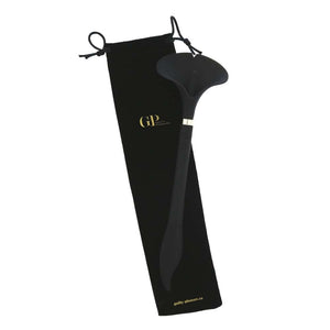 Stimulateur intime noir à la forme ergonomique, présenté avec un pochon de rangement noir siglé, photographié sur fond blanc dans une mise en scène épurée et raffinée.