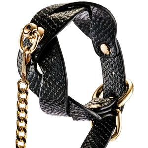 Modèle portant un collier BDSM noir texturé avec chaîne dorée et dragonne assortie, accessoire de contrainte proposé par Brigade Mondaine Paris.