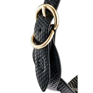 Modèle portant un collier BDSM noir texturé avec chaîne dorée et dragonne assortie, accessoire de contrainte proposé par Brigade Mondaine Paris.