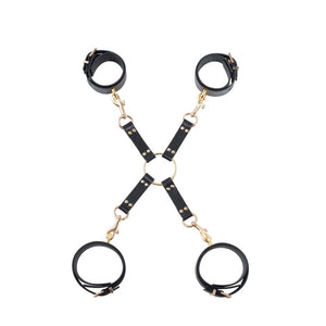 Hogtie BDSM en cuir noir composé de quatre sangles reliées par un anneau central doré, équipé de mousquetons métalliques pour la fixation.