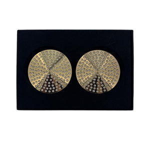 Paire de cache-tétons dorés circulaires ornés de strass brillants, présentés dans un écrin noir sur fond blanc, avec une esthétique élégante et minimaliste.