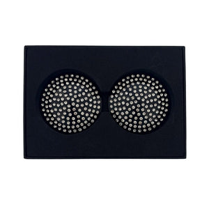 Paire de cache-tétons noirs circulaires ornés de strass brillants, présentés dans un écrin noir sur fond blanc, avec une esthétique élégante et minimaliste.
