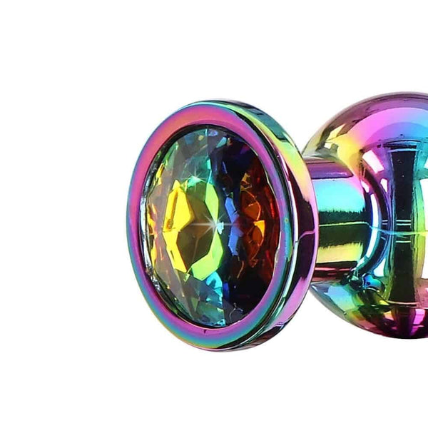 Plug anal en cristal irisé multicolore, à la forme arrondie et lisse, doté d’une base facettée brillante, présenté sur fond blanc dans une esthétique épurée et élégante.
