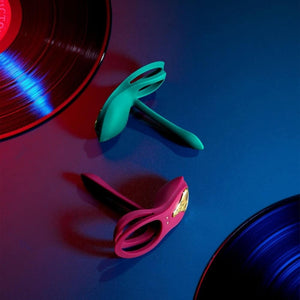 Vibromasseur portable au design ergonomique présenté avec son écrin, posé sur un décor aux nuances bleues et rouges, sélection Brigade Mondaine Paris. Sextoys Electriques