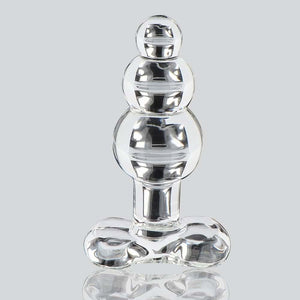 Plug anal en verre transparent à forme facettée avec base évasée, présenté sur fond clair, finition brillante, sélection Brigade Mondaine Paris.