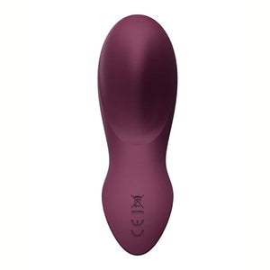 Vibromasseur portable de couleur prune avec détails dorés, design ergonomique et commandes intégrées, présenté sur fond blanc, sélection Brigade Mondaine Paris.