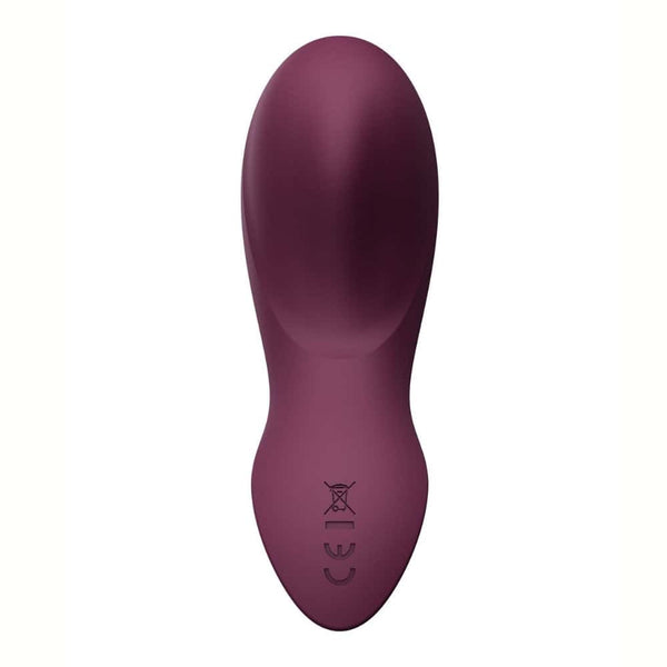 Vibromasseur portable de couleur prune avec détails dorés, design ergonomique et commandes intégrées, présenté sur fond blanc, sélection Brigade Mondaine Paris.
