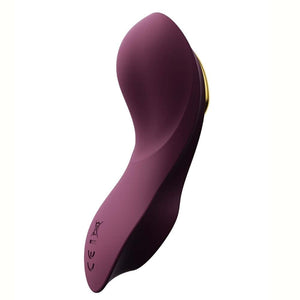 Vibromasseur portable de couleur prune avec détails dorés, design ergonomique et commandes intégrées, présenté sur fond blanc, sélection Brigade Mondaine Paris.
