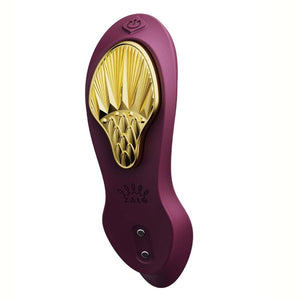 Vibromasseur portable de couleur prune avec détails dorés, design ergonomique et commandes intégrées, présenté sur fond blanc, sélection Brigade Mondaine Paris.