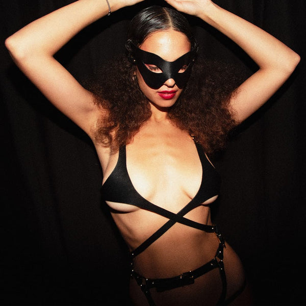 Soutien gorge en cuir noir de la marque Elif Domanic. Ce soutien gorge s’apparente presque à la forme d’un harnais grâce à ses tours de taille en cuir qui s’attache au niveau du nombril par le biais d’une fine boucle argenté. La poitrine est cachée par une pièce recouvrant une petite partie des seins. Cet ensemble est relié aux bretelles par deux anneaux argentés avec à l’arrière une lanière munie d’une boucle et de quelques clous. A l’intérieur de la bretelle de droite se trouve une plaquette argentée embo