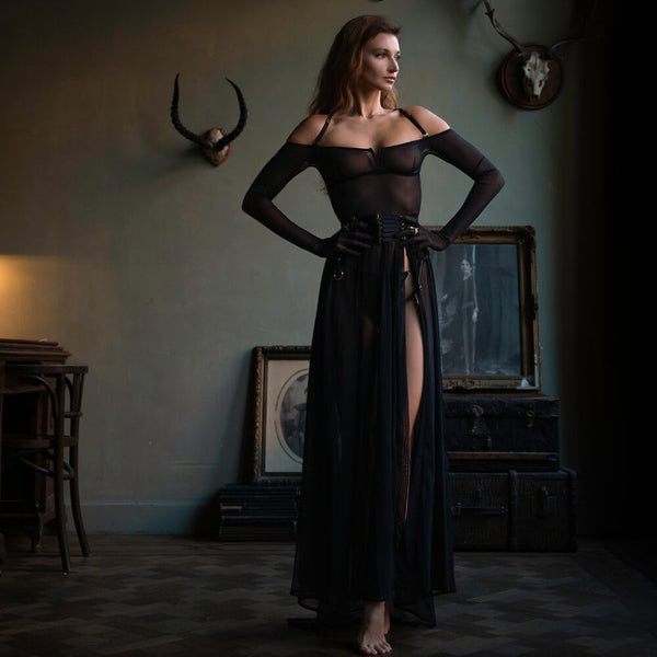 Robe longue en résille noire drapé fluide avec une traîne subtile manches longues avec gants intégrés avec bretelles amovibles inclus paire avec finitions dorées, l’autre en noir porté avec un harnais noir en élastique travail complexe dans le dos détails en anneaux dorés, les sangles ajustables et les attaches multiples