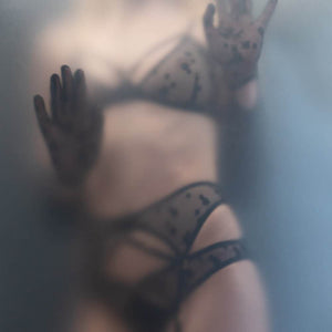 Ensemble de Lingerie en tulle français noir brodé d’étoiles avec détails plaqués or 24k avec une culotte un soutien-gorge et un porte-jarretelles. Associé avec des gants longs également bordés d'étoiles en tulle noir.