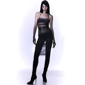 Ensemble Top et jupe Les Indolentes Collection Caravasar de la marque Gonzales Affaires. Cette jupe s’arrête en dessous des genoux. Le produit est confectionné à partir d’une partie en tulle transparent gris des genoux jusqu’au nombril. Une couture est située sur le côté de la robe afin d’obtenir ou non un rendu plissée de la jupe en saisissant l’anneau au bout de la jupe. Ensuite une ceinture est placée au niveau des hanches avec trois élastiques fins ornés d’anneaux argenté au centre de la ceinture. Les d