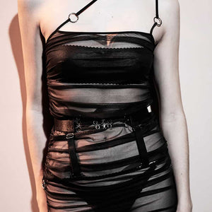 Ensemble Top et jupe Les Indolentes Collection Caravasar de la marque Gonzales Affaires. Cette jupe s’arrête en dessous des genoux. Le produit est confectionné à partir d’une partie en tulle transparent gris des genoux jusqu’au nombril. Une couture est située sur le côté de la robe afin d’obtenir ou non un rendu plissée de la jupe en saisissant l’anneau au bout de la jupe. Ensuite une ceinture est placée au niveau des hanches avec trois élastiques fins ornés d’anneaux argenté au centre de la ceinture. Les d