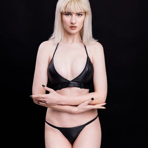 Culotte en cuir noir minimaliste et top Lora Corium de House of SXN. Ensemble fétiche haut de gamme, cuir souple, anneaux métalliques et allure directe.