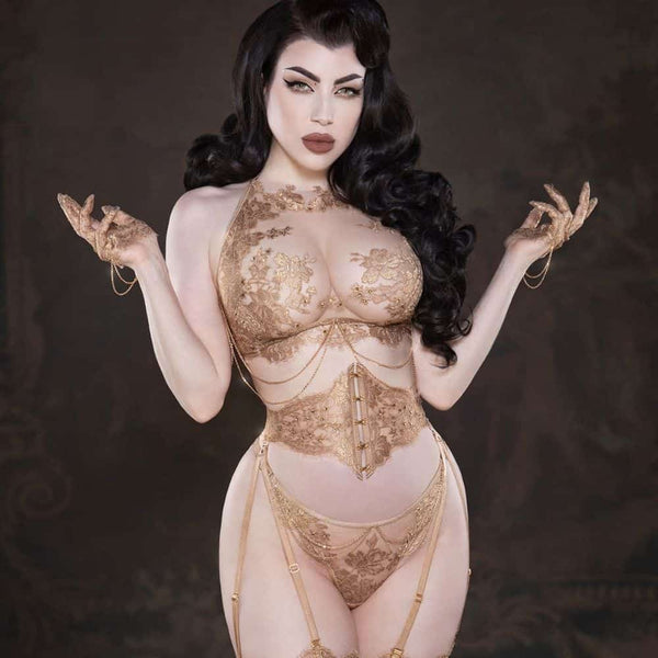 Le corset taille AIMÉE incarne l’élégance ultime, réalisé à la main avec de la dentelle Leavers française en or rosé et un tulle ultra-transparent pour un galbe parfait. Des crochets et œillets dorés, cousus avec soin, et un laçage au dos permettent une coupe personnalisée. Sa structure renforcée, dotée de baleines souples, met en valeur la taille, tandis que les bretelles doubles amovibles offrent une flexibilité maximale. Associez-le à la culotte brésilienne taille haute AIMÉE, également confectionnée ave