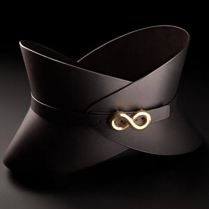 Corset ceinture HUDIA IINFYNII en cuir noir avec fermoir métallique infini porté sur un tailleur noir, accessoire structurant et graphique proposé par Brigade Mondaine Paris