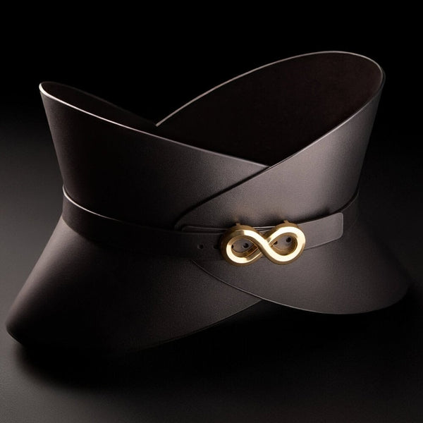 Corset ceinture HUDIA IINFYNII en cuir noir avec fermoir métallique infini porté sur un tailleur noir, accessoire structurant et graphique proposé par Brigade Mondaine Paris
