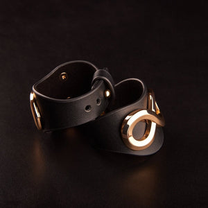 Bracelets SASKIA IINFYNII en cuir noir avec anneau métallique doré, détail de bracelet ajustable, accessoire de corps sélection Brigade Mondaine Paris