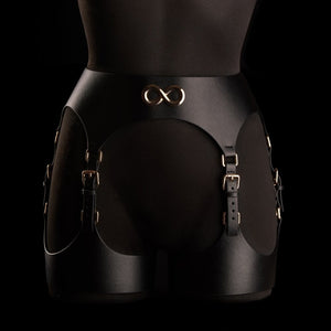 Porte-jarretelles Neria en cuir noir IINFYNII présenté chez Brigade Mondaine Paris, porté sur mannequin, taille haute structurée, sangles réglables et finitions métalliques dorées.