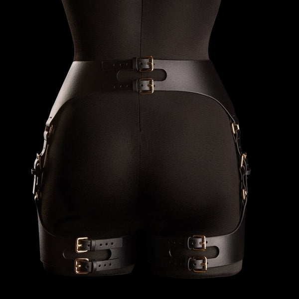 Porte-jarretelles Neria en cuir noir IINFYNII présenté chez Brigade Mondaine Paris, porté sur mannequin, taille haute structurée, sangles réglables et finitions métalliques dorées.