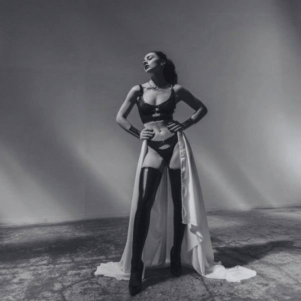 Brassière et tanga Luxure CATANZARO portés sur modèle, en tulle noir avec découpes graphiques et finitions lisses, ensemble haut de gamme proposé par Brigade Mondaine.