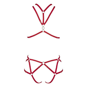 Harnais Nicole CATANZARO rouge porté sur body noir en tulle, avec sangles ajustables et anneaux métalliques, accessoire haut de gamme proposé par Brigade Mondaine.