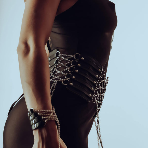 Ceinture corset en cuir et chaînes inox, doublée de daim pour confort. Manchette en cuir italien avec chaîne en argent sterling. Ajustables, raffinées et sensuelles. Modèles sur commande.