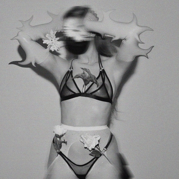 Lingerie en tulle noir à double couche, noué derrière la nuque par un élastique spaghetti. Anneaux métalliques argentés pour une touche espiègle et élégante.