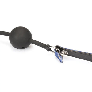 Ball gag Denim LIEBE SEELE avec boule en silicone noire et sangle ajustable en cuir et textile bleu, anneaux métalliques latéraux, présenté sur fond blanc en vue produit détaillée