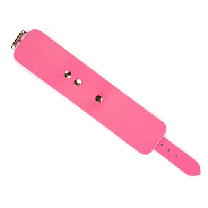 Menottes Lustre Rosa LIEBE SEELE en cuir rose lisse avec rivets métalliques dorés et sangle réglable, présentées sur fond blanc