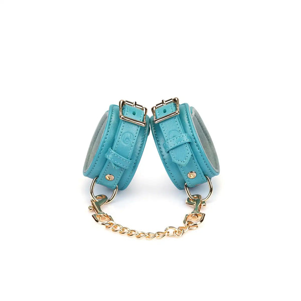 Menottes Agneau Bleu LIEBE SEELE en cuir bleu doublé agneau clair avec fermeture réglable, anneaux métalliques et chaîne dorée, photographiées sur fond blanc