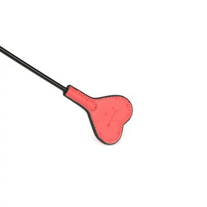 Cravache Angel’s Kiss LIEBE SEELE avec tête en forme de cœur rose et manche noir texturé, présentée sur fond blanc